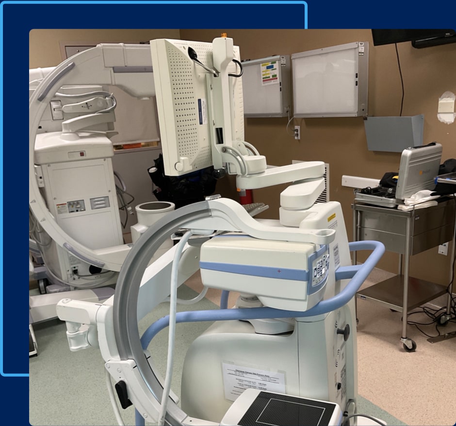 C-arm machine at front with other equipment in the back.