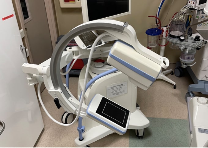 A white colored C-arm machine.