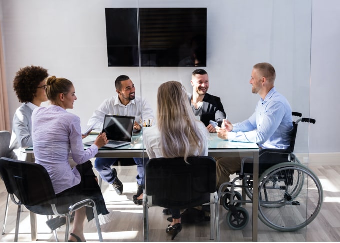 Six people having a discussion at a board room table.