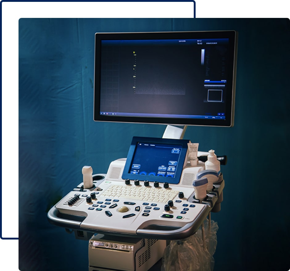 An ultrasound monitor with a control panel and a keyboard.