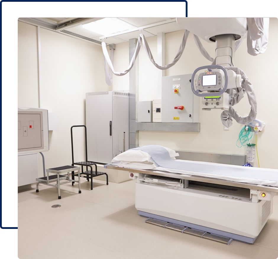 An X-ray machine in a room with white painted walls.